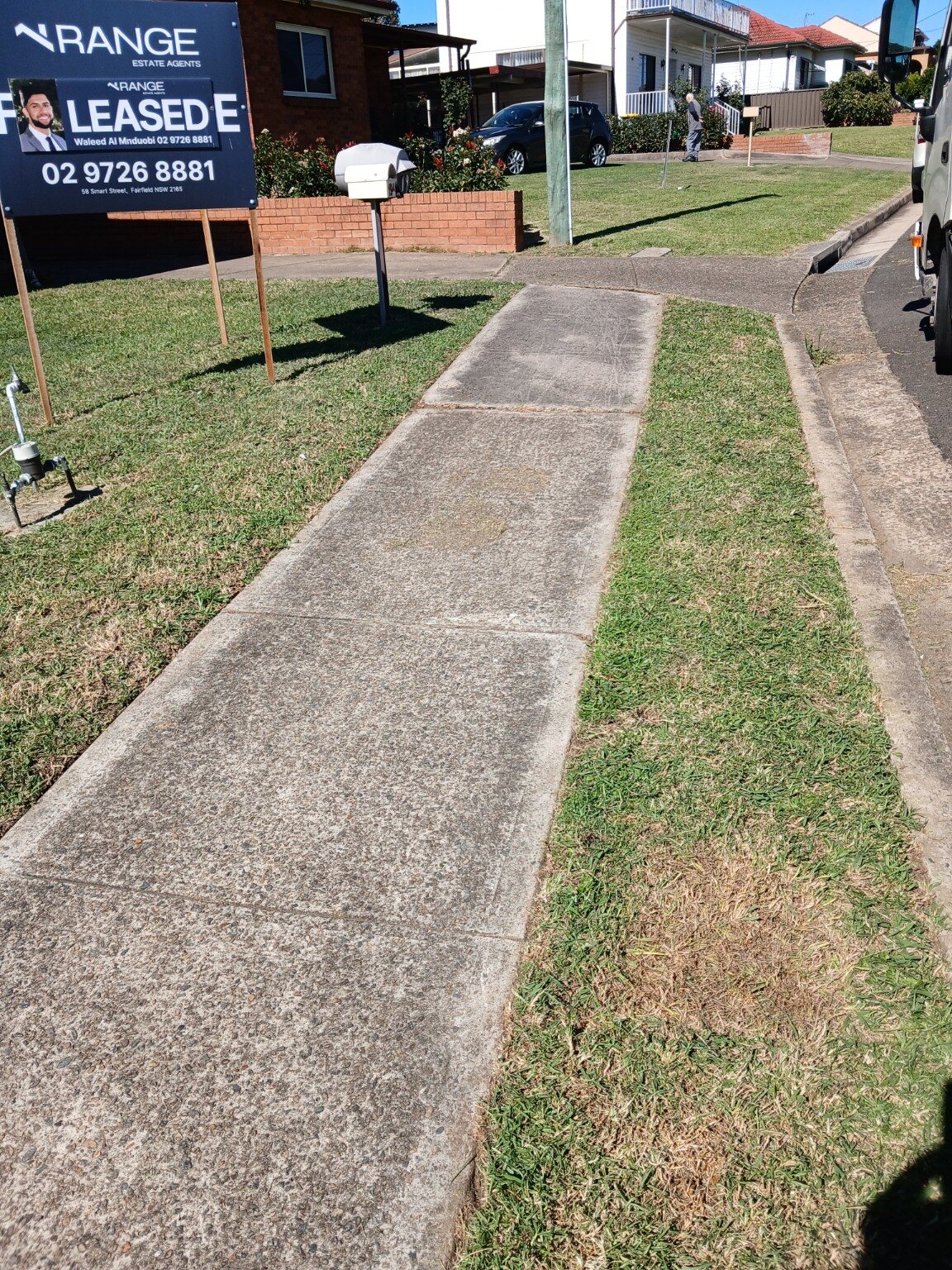 Sharp, freshly edged nature strip lawn running alongside a footpath
